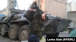 Солдат украинской армии позирует для фото с полученной посылкой.