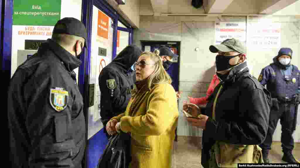 Жінка свариться з працівником поліції у зв’язку з відсутністю спеціальної перепустки для  пасажирів