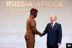 Правитель Буркина-Фасо Ибрагим Траоре и президент России Владимир Путин пожимают друг другу руки на саммите "Россия-Африка" в Санкт-Петербурге. 27 июля 2023 года