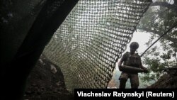 Український військовий несе снаряд до самохідної гаубиці М109 поблизу Костянтинівки на Донеччині, липень 2025 року