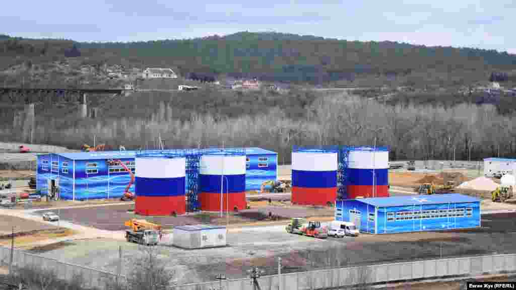 Площадка водопроводных очистных сооружений (ВОС). Очистные сооружения – самое большое здание. Одноэтажное здание на переднем плане – это насосная станция второго подъема. Резервуары чистой воды объемом 1000 кубов каждый, военные строители выкрасили в цвета российского флага