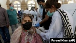 A woman receives a shot of the Sinopharm coronavirus vaccine from a health worker at a vaccination center in Karachi earlier this month.