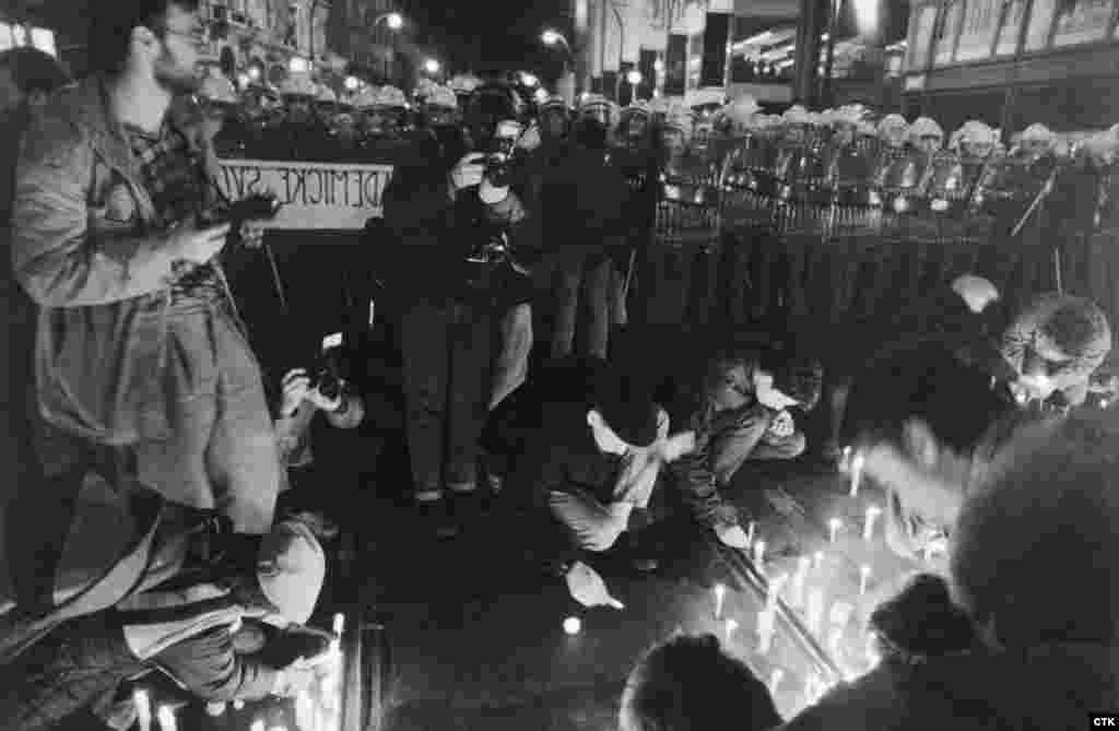 Students light candles near a police cordon. Although the protests were nonviolent and students chanted "We have bare hands" to tell authorities that they were unarmed, riot police sealed off escape routes and attacked them.  