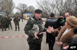 Женщина разговаривает с украинским военным в Керчи, 4 марта 2014 года