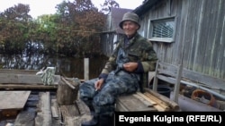 Алексей Воронин рядом со своим затопленным домом в разгар наводнения.