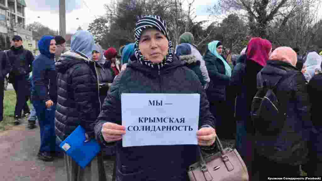 Дети и жены крымскотатарских активистов держат в руках листы бумаги с надписями «Мы – крымская солидарность» и «Верните 166-ти детям их отцов»