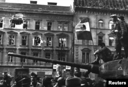 Будапешт. Фото зроблене під час Угорської революції в період між 23 жовтня і 4 листопада 1956 року. На угорському прапорі, встановленому на відібраному жителями Будапешта танкові, вирізаний комуністичний герб