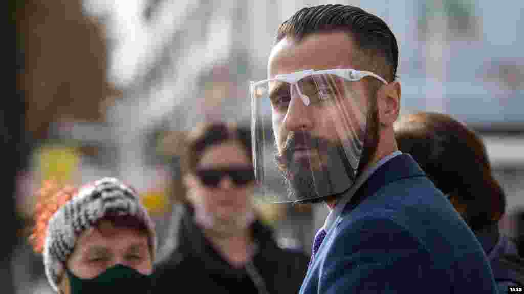 Мужчина в защитном щите в Симферополе во время пандемии коронавируса на полуострове, 16 ноября 2020 года.  По состоянию на 21 декабря 2020 года в Крыму выявили 350 новых случаев коронавирусной инфекции, в том числе 16 случаев с бессимптомным течением заболевания. По данным российского главы Крыма Сергея Аксенова, количество выздоровевших за сутки составляет 18 человек, выздоровевших за весь период – 16 410 человек.  Данные российских властей Крыма и Севастополя о заболеваемости коронавирусом не подтверждены международными организациями и другими независимыми источниками. Правозащитники утверждают, что эта статистика существенно занижена, поскольку не отражает многих важных факторов, включая инфицирование в рядах российских военных и спецслужб