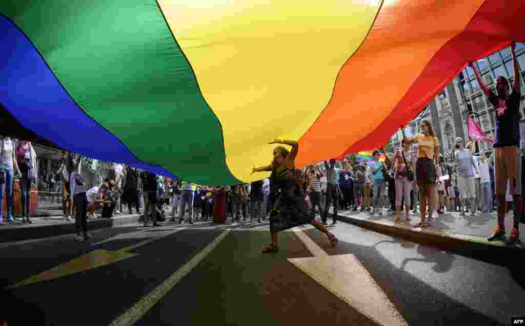 A woman dances under a huge rainbow flag during the good-humored festivities. 
