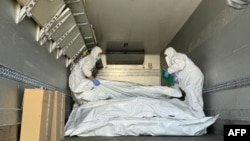 Представники Міжнародного Червоного Хреста перевіряють мішки з останками військовослужбовців під час обміну тілами, серпень 2024 року