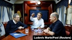 Президент Франції Емманюель Макрон (посередині), канцлер Німеччини Олаф Шольц (праворуч) і прем’єр-міністр Італії Маріо Драґі (ліворуч) у потязі, що прямує до Києва із Польщі, 16 червня 2022 року