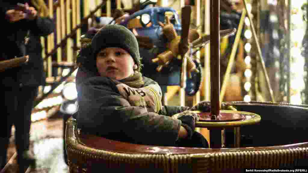 Хлопчик чекає на запуск каруселі. Між Софіївським та Михайлівським соборами працює цілий парк атракціонів, а також величезний ярмарок, де можна скуштувати різдвяних смаколиків та випити запашного глінтвейну  