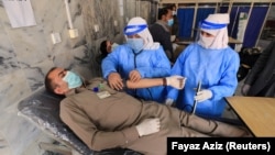 A health workers undergoes a medical checkup after receiving a dose of Sinopharm's coronavirus vaccine, donated by China, at a vaccination center in Peshawar on February 3.