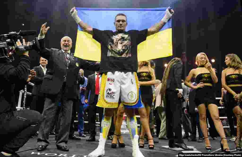 Український боксер Олександр Усик, який завоював титул чемпіона світу за версіями Всесвітньої боксерської ради (WBC), Всесвітньої боксерської організації (WBO), Всесвітньої боксерської асоціації (WBA) і Міжнародної боксерської федерації (IBF) у вазі до 90,71 кілограма в об'єднавчому бою з російським боксером Муратом Гассіевим, у фіналі Всесвітньої боксерської суперсерії WBSS. Москва, 22 липня 2018 року. НА ЦЮ Ж ТЕМУ