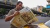 An Iranian man reads a newspaper on a Tehran street on April 12, with the front page focusing on the Iran-US nuclear talks in Oman.