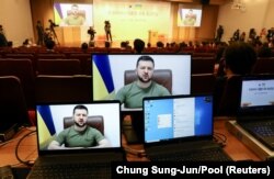 Президент України Володимир Зеленський (на екрані) під час звернення через відеозв'язок до парламенту Південної Кореї. Сеул, 11 квітня 2022 року