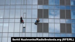 Промислові альпіністи на тлі фасаду одного з київських хмарочосів – бізнес-центру Gulliver