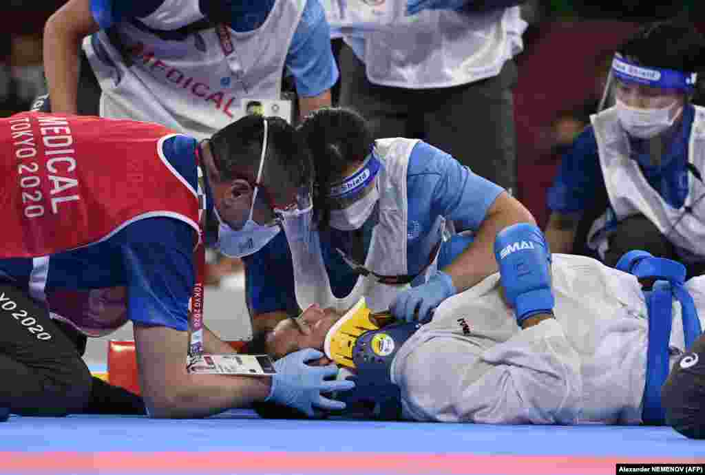 Иранец Саджад Ганджзаде осматривается медиками после травмы в финале соревнований по карате (кумите) свыше 75 кг против Тарега Хамеди из Саудовской Аравии во время Олимпийских игр 2020 года в Токио, 7 августа 2021 года