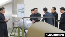 Лідер Північної Кореї Кім Чен Ин (с) дає вказівки вченим-ядерникам біля термоядерного вибухового пристрою (ймовірно, макета), фото державного агентства ЦТАК. За повідомленням Пхеньяна, це було 2 вересня 2017 року, за день до випробування