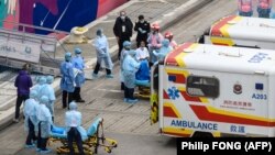 Одного з пасажирів круїзного лайнера World Dream перевозять до лікарні у Гонконзі, 5 лютого 2020 року