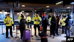 Сотрудники службы безопасности проверяют документы пассажиров на железнодородной станции Каструп под Копенгагеном, 4 января 2016 года