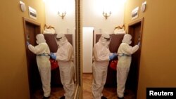 Zdravstveni radnici ulaze u hotelsku sobu u kojoj se liječe beskućnici zaraženi korona virusnom. Hotele je iznajmio grad Prag kako bi se beskućnici u njima oporavljali. Češka, 22. marta 2021.