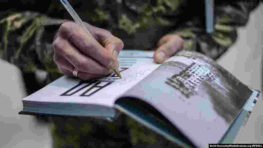 Боєць підписує примірник на пам’ять