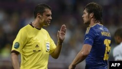 Главный арбитр матча чемпионата Европы по футболу Украина - Англия Виктор Кашшаи (Венгрия) и игрок сборной Украины Артем Милевский. 19 июня 2012 г