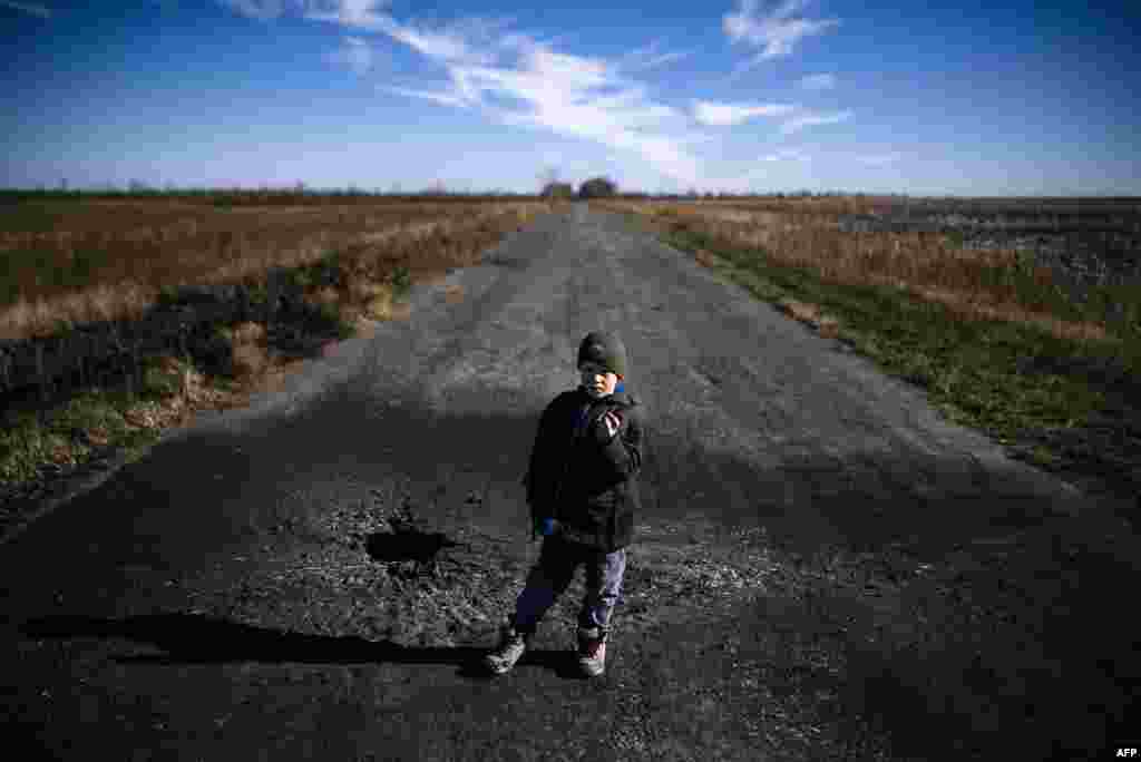 Хлопчик показує шматок шрапнелі після мінометного обстрілу українських позицій біля села Набережне, 29 жовтня 2014 року