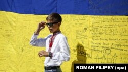 Хлопчик на тлі українського прапора із побажаннями та вдячністю оборонцям України. День Незалежності України. Київ, 24 серпня 2015 року