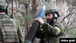 Ukrainian forces prepare to fire artillery rounds near Kupyansk.