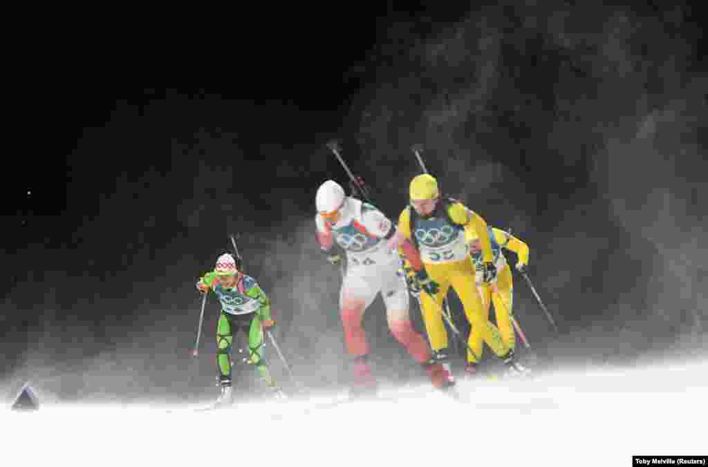 Биатлон: Надежда Писарева из Беларуси (слева) соревнуется на дистанции в лыжном центре «Альпенсия» в Пхенчхане. Вероника Новаковская из Польши идет на трассе справа