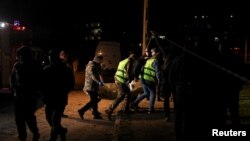 Співробітники екстреної служби несуть тіло на місці російського ракетного удару в житловому районі, Кривий Ріг, Україна, 4 квітня 2025 року