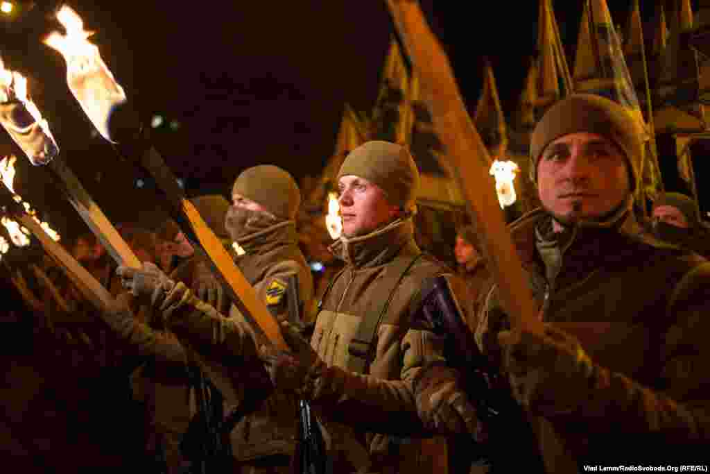 Бійці полку «Азов», запаливши смолоскипи, стоять біля пам’ятника князю Святославу перед його урочистим відкриттям