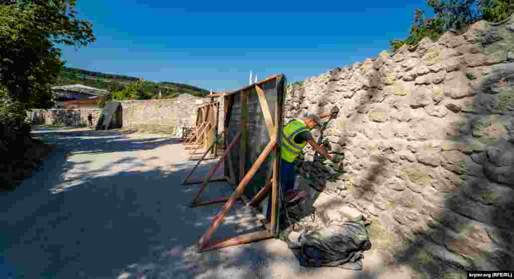 Туда ведет Исторический переулок, где работают реставраторы – «расшивают» белым цементом кладку забора дворца