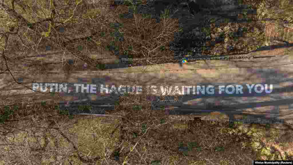 Послание до Путин, нарисувано с шалони пред руското посолство във Вилнюс, Литва, през февруари 2022 г. То гласи: "Путин, Хага те очаква".