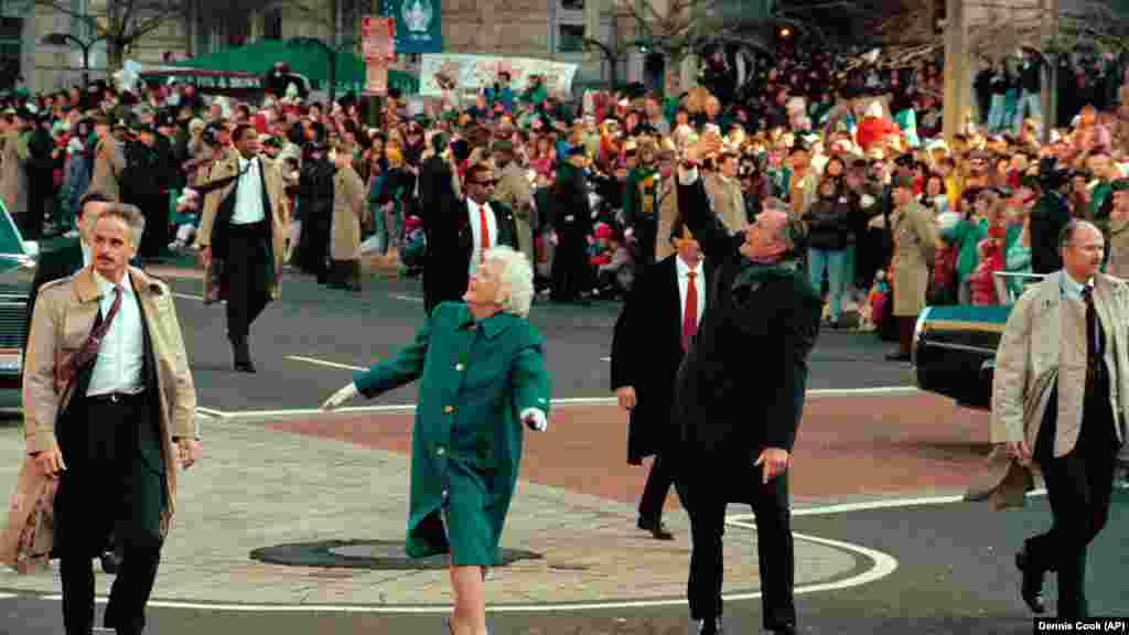 Predsjednik George Bush, desno, i prva dama Barbara Bush mašu okupljenima duž Avenije Pennsylvania. 41. predsjednik je položio zakletvu 20. januara 1989. godine.  