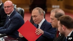 Ruski predsjednik Vladimir Putin sređuje dokumente na početku bilateralnog sastanka s kineskim liderom Xi Jinpingom u Pekingu, 2. septembra.