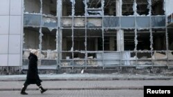 Иллюстративное фото. Женщина проходит вдоль разрушенного здания. Донецк, Февраль 2015 года