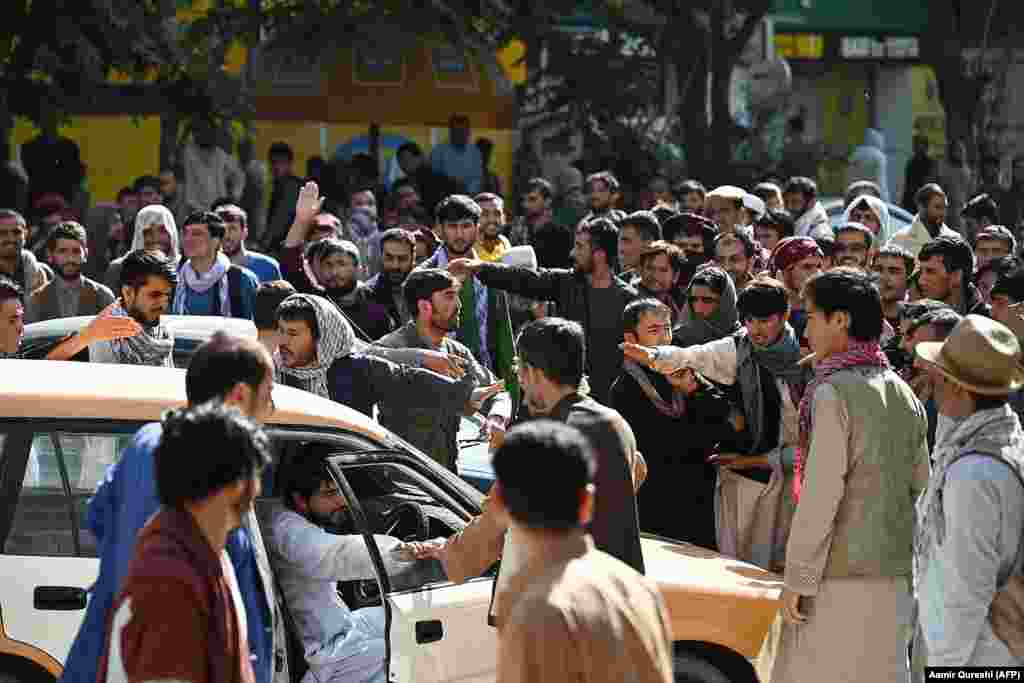 Crowds gather outside a closed branch of a Kabul bank on August 28. Since the Taliban seized power in Kabul, many government buildings, banks, schools, and universities have remained closed. As prices rise, cash is reportedly becoming harder to acquire.  