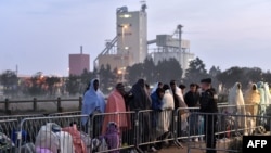 Полицейский наблюдает за мигрантами после ликвидации лагеря беженцев в Кале