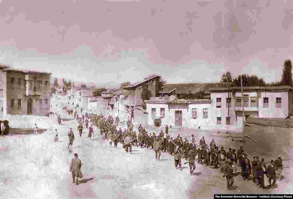 Fotografie înfățișând un grup de bărbați armeni deportați sub amenințarea armelor, în orașul Kharpert.