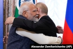 Президент России Владимир Путин (справа) обнимает премьер-министра Индии Нарендру Моди во время их встречи на полях саммита БРИКС в Казани 22 октября 2024 года