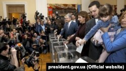 Діючий президент України і кандидат на президентських виборах Петро Порошенко (посередині) голосує разом із членами своєї родини на виборчій дільниці у Києві, 31 березня 2019 року