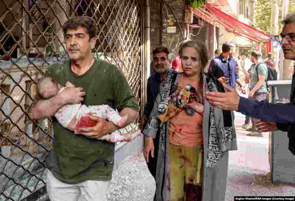 Чоловік несе дитину після вибуху в Тегерані, Іран, 15 червня