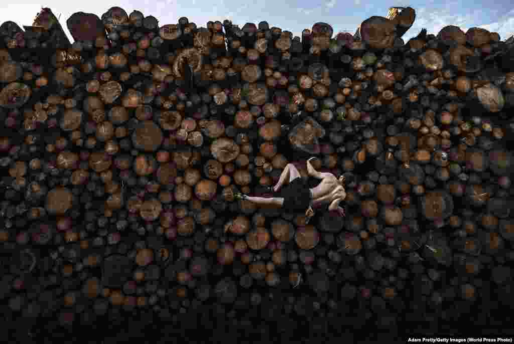 Георг піднімається на колоди під час тренування з болдерингу в Кохель-ам-Зее, Баварія, Німеччина, 15 вересня. Болдеринг (англ. bouldering — скелелазіння по валунах) – різновид скелелазіння на невисоких скельних утвореннях або штучних стендах без мотузки та страхувальної системи, зазвичай не більше шести метрів у висоту. Історично болдеринг починався як тренування для більш амбітних занять скелелазінням і альпінізмом, але перетворився в самостійний вид спорту. Зали для скелелазіння і спортивні споруди в Мюнхені були закриті через тривалий карантин через пандемію COVID-19, тому спортсмени стали творчо підходити до своїх методів тренувань.   Спортивні змагання: Перший приз, одиночний розряд – Адам Претті, Getty Images