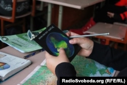 Учні розглядають 3D-листівку з материками