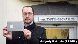 Табличка в руках инициатора установки памятного знака Григория Тарасенко