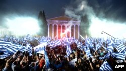 Supporters of the leader of the conservative party New Democracy, Antonis Samaras, wave flags during a pre-election speech in Athens.