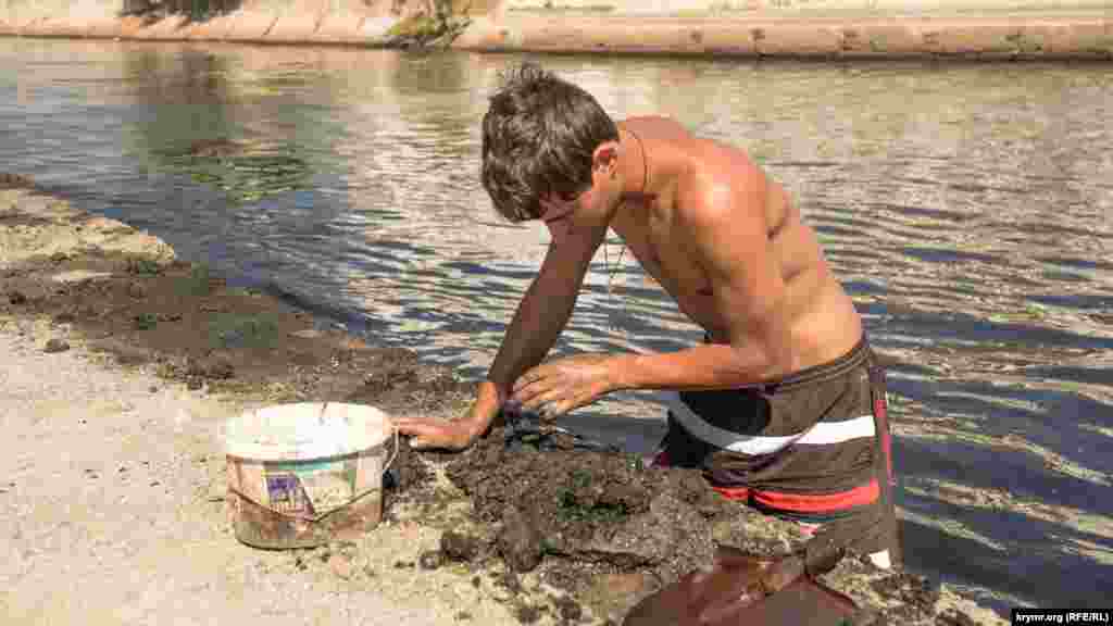 В речном иле местный житель Сергей выискивает червей. По словам парня, на них он удочкой ловит кефаль, лобана, пеленгаса, королевку, нередко попадаются и несъедобные виды рыб – зеленуха, собака
